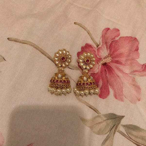 An ordinary phone photo of earrings on a plain surface